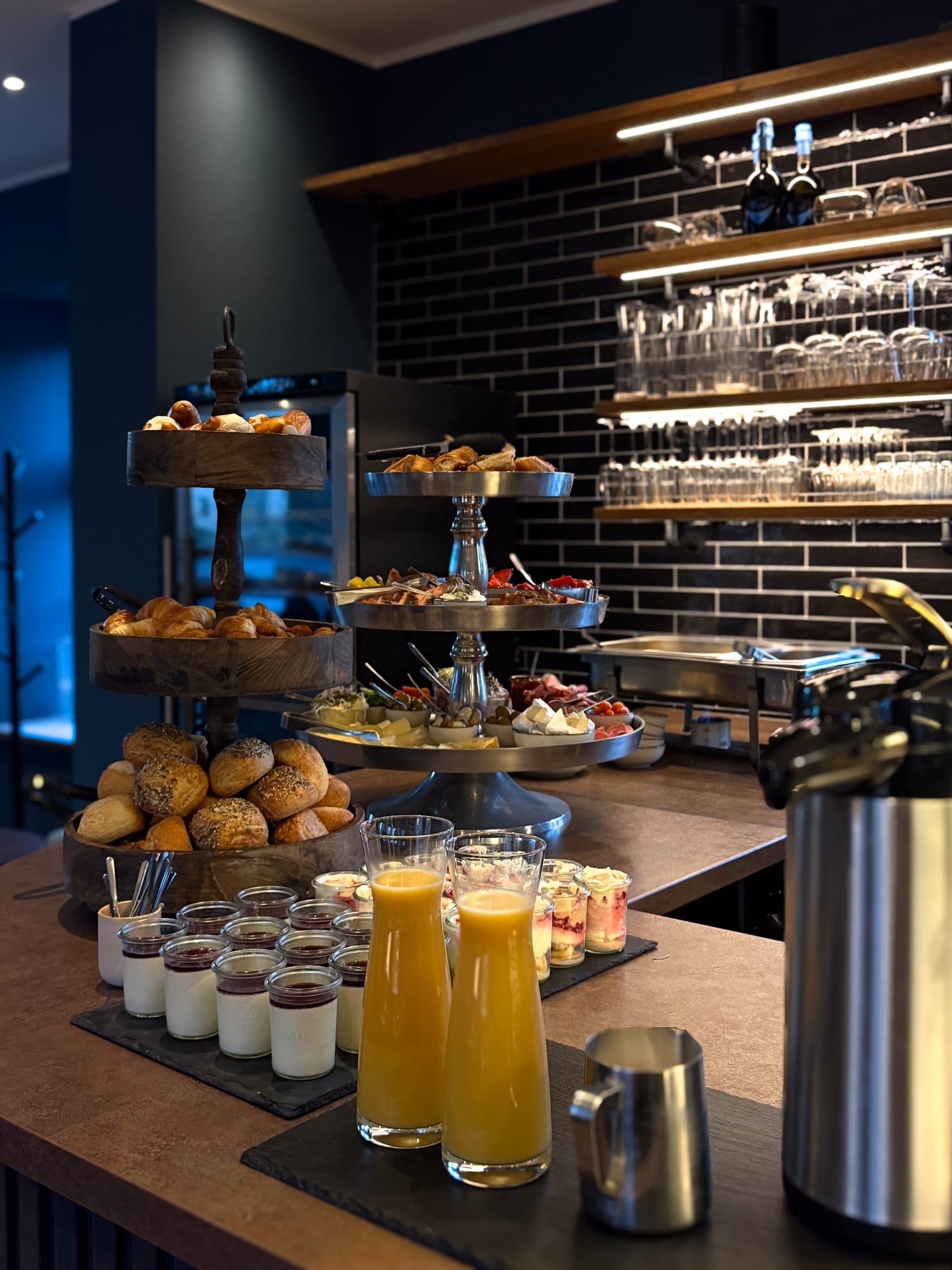 Frühstücks-Buffet an der Bar — Frühstücks-Buffet an der Bar im Torhaus auf der Carlshöhe: Etagère mit Brötchen, Glaswand, Orangensaft-Karaffen