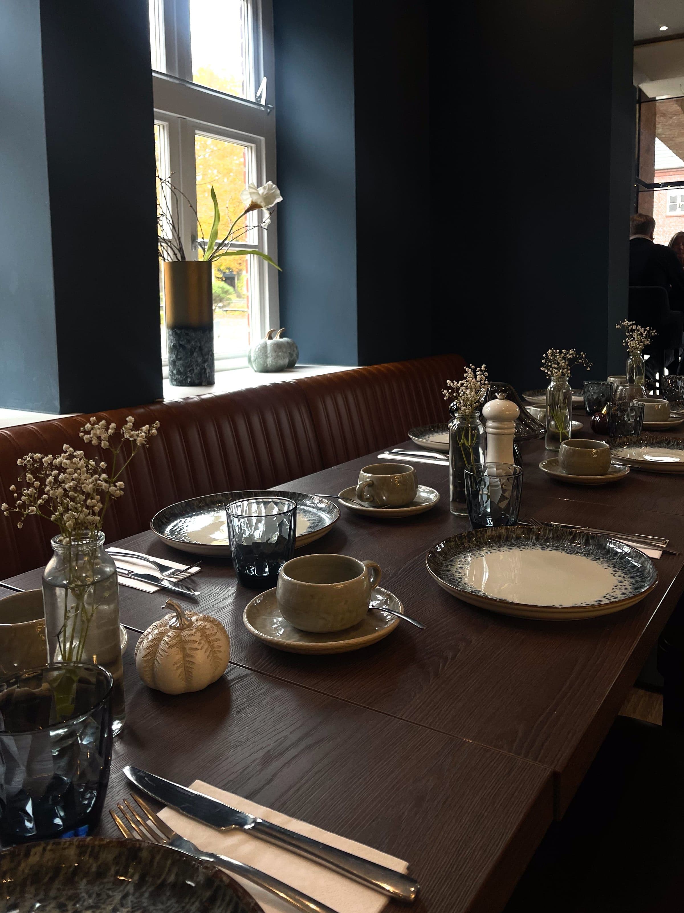 Festlich gedeckte lange Tafel am Sprossenfenster für eine Konfirmation oder Taufe